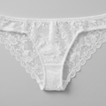 Women's white lace bikini brief flat lay showing intricate lace and net mesh detail